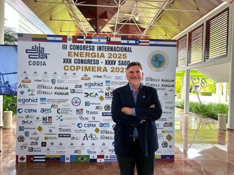 Ing. José Luis Maccarone de pie frente a un panel de patrocinadores