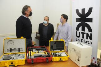 imagen deL Decano de la facultad, el director de departamento y un docente de la facultad con el nuevo equipamiento sobre la mesa  